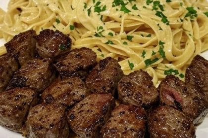 Classic Caprese Salad on a white rectangular platter, featuring alternating slices of ripe red tomatoes and fresh mozzarella, layered with green basil leaves.